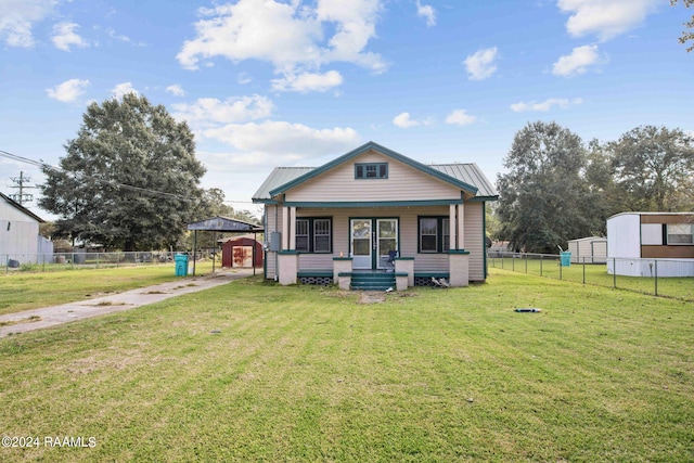 bungalow-style home with a front yard and a storage shed