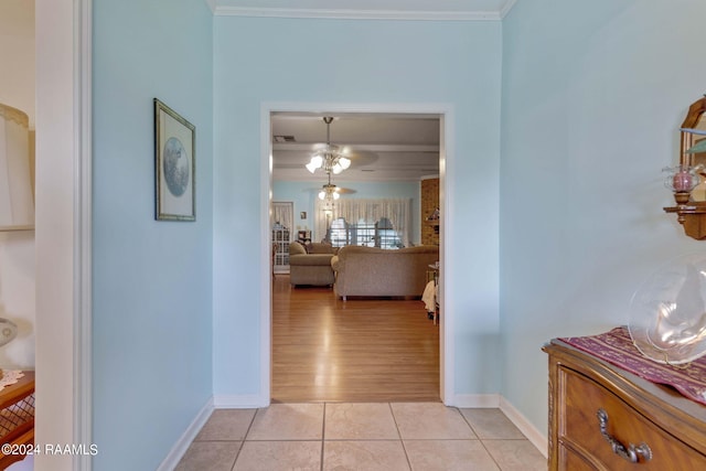 hallway with light hardwood / wood-style flooring and crown molding