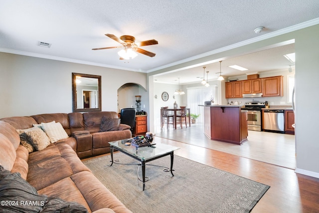 living room with light hardwood / wood-style floors, crown molding, a textured ceiling, and ceiling fan