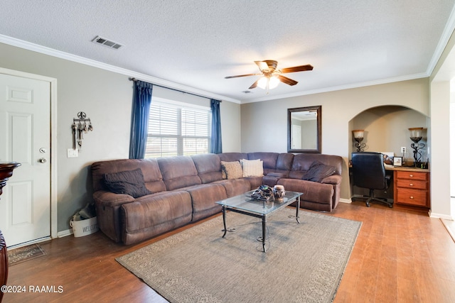 living room featuring ceiling fan, hardwood / wood-style flooring, crown molding, and a textured ceiling