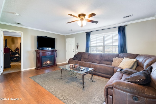 living room with ceiling fan, a textured ceiling, crown molding, and dark hardwood / wood-style flooring