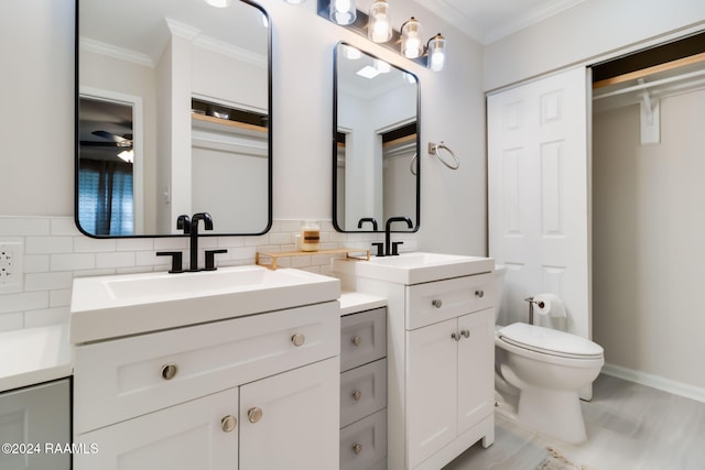 full bath with toilet, crown molding, and a sink