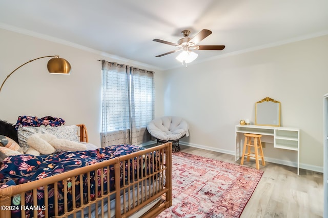 bedroom with wood finished floors, crown molding, a ceiling fan, and baseboards