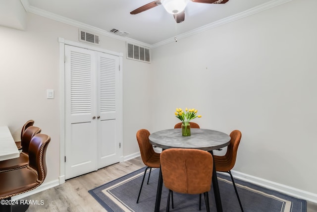dining space with wood finished floors, visible vents, and baseboards