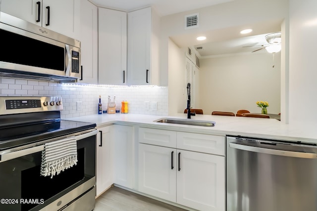 kitchen featuring a sink, ceiling fan, stainless steel appliances, and light countertops