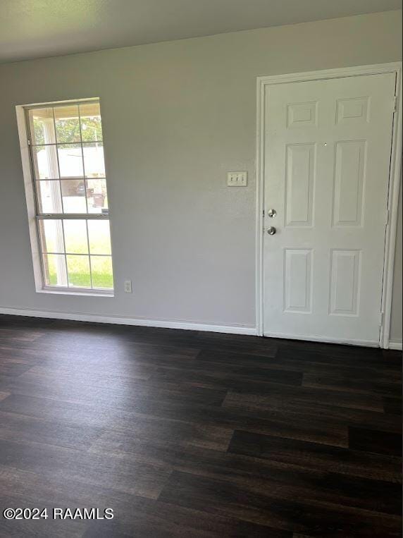 unfurnished room with dark hardwood / wood-style flooring