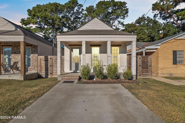 view of front of house featuring covered porch and a front yard