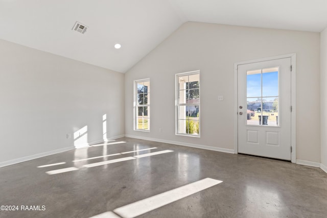 unfurnished room featuring concrete flooring and high vaulted ceiling