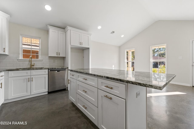 kitchen with light stone countertops, dishwasher, white cabinets, and vaulted ceiling