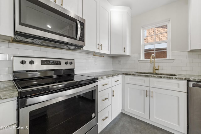 kitchen with white cabinets, stone countertops, sink, and stainless steel appliances