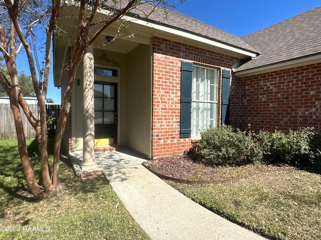 doorway to property with a lawn