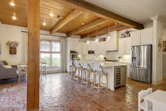 kitchen with a kitchen island with sink, appliances with stainless steel finishes, wooden ceiling, and white cabinetry