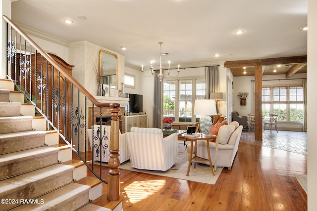 living room with hardwood / wood-style flooring, a notable chandelier, and crown molding