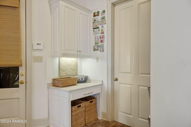 interior space featuring decorative backsplash and white cabinetry