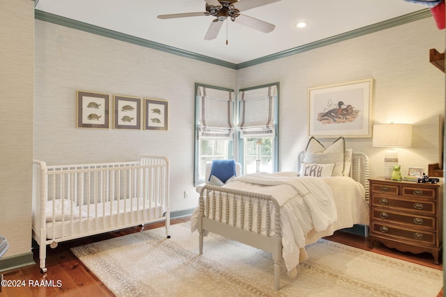 bedroom with ornamental molding, hardwood / wood-style flooring, and ceiling fan