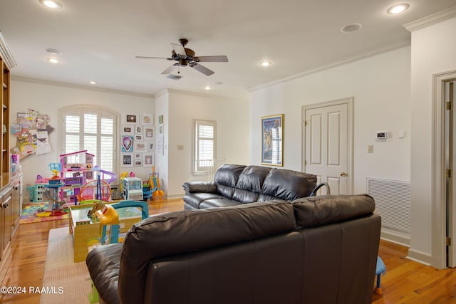 living room with light hardwood / wood-style floors, ornamental molding, and a wealth of natural light