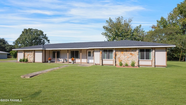 ranch-style house featuring covered porch and a front lawn