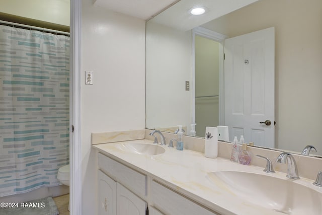 bathroom featuring vanity, toilet, and curtained shower