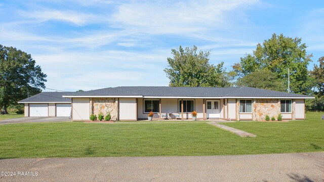 single story home with covered porch, a front lawn, and a garage