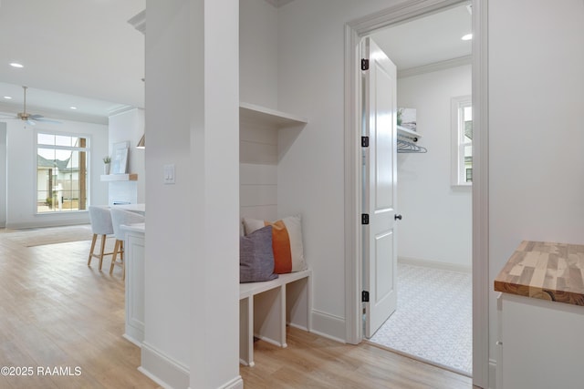 corridor featuring ornamental molding, recessed lighting, light wood-style flooring, and baseboards