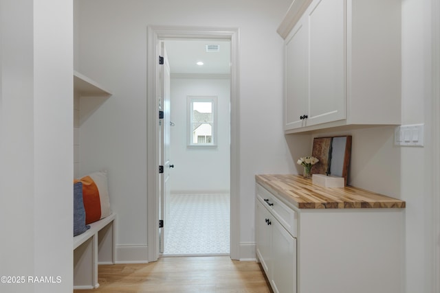 interior space with recessed lighting, visible vents, baseboards, light wood finished floors, and crown molding