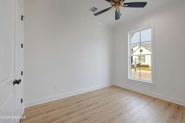 unfurnished room with light wood-type flooring, visible vents, crown molding, and baseboards