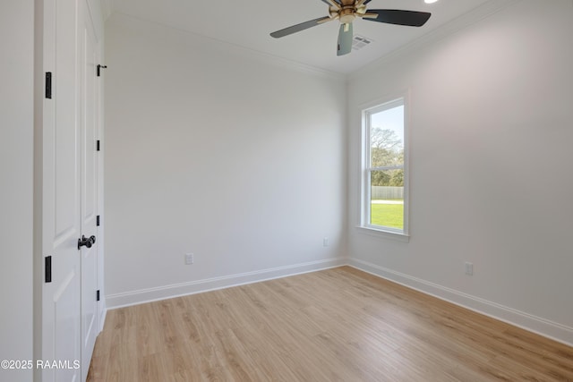 empty room with a ceiling fan, light wood-style flooring, ornamental molding, and baseboards