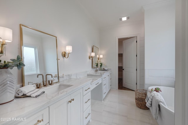 full bathroom featuring a sink, visible vents, a freestanding bath, ornamental molding, and double vanity