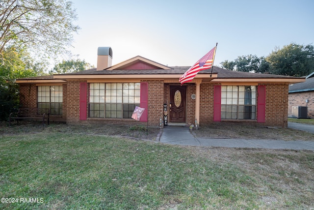 single story home featuring a front lawn and central AC unit