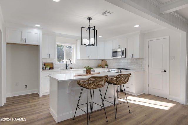 kitchen featuring a center island, stainless steel appliances, and white cabinets