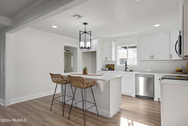 kitchen featuring appliances with stainless steel finishes, white cabinets, and a center island