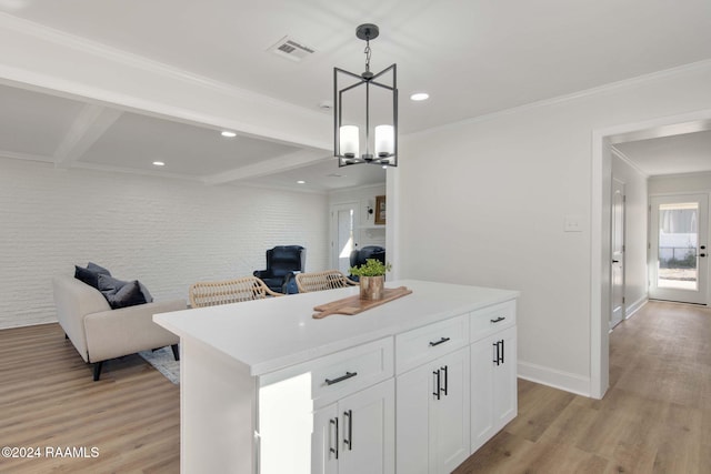 kitchen featuring beam ceiling, hanging light fixtures, white cabinetry, light hardwood / wood-style floors, and a center island