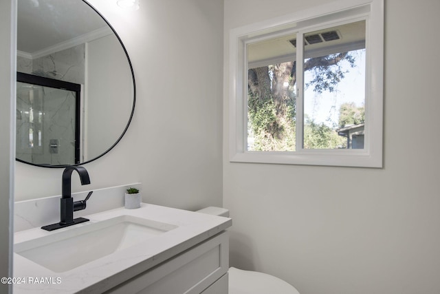 bathroom with vanity, toilet, crown molding, and an enclosed shower