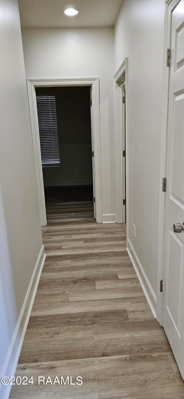 corridor with light hardwood / wood-style floors