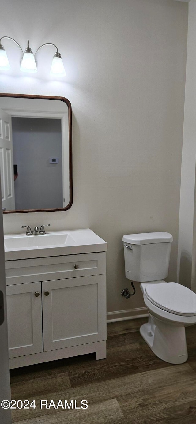 bathroom with vanity, toilet, and wood-type flooring