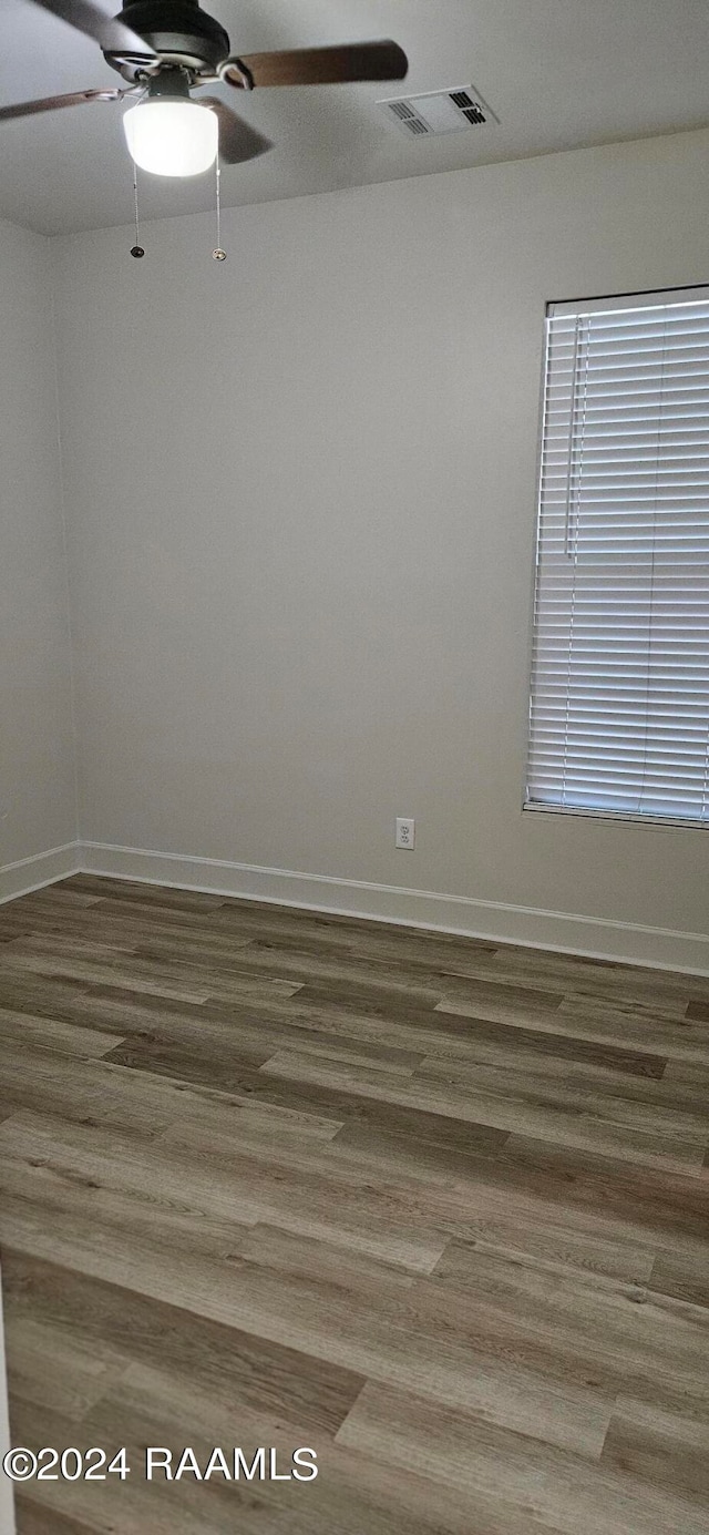 empty room with hardwood / wood-style flooring and ceiling fan