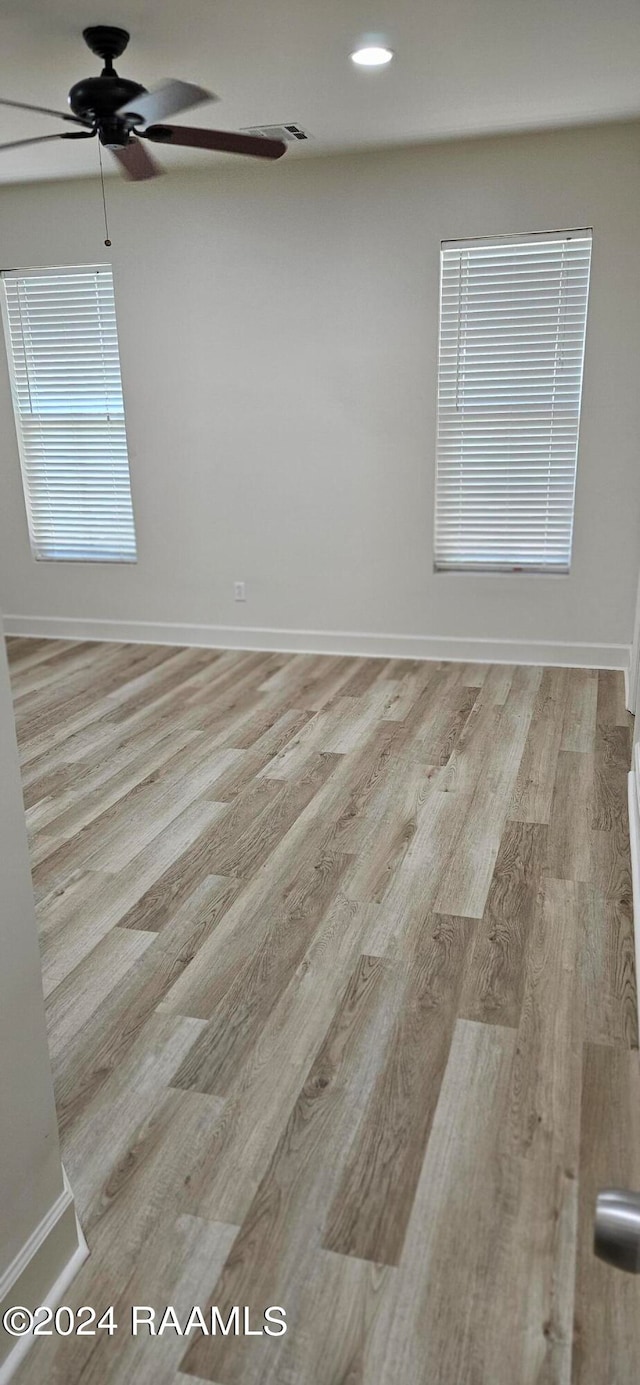 unfurnished room with light wood-type flooring and ceiling fan