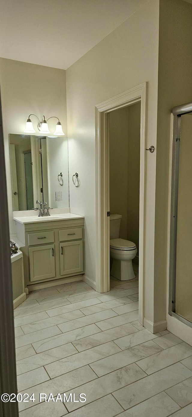 bathroom with vanity, toilet, and a shower with shower door