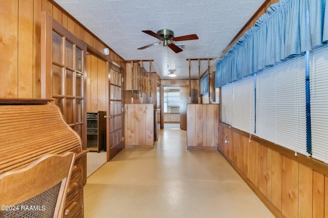 kitchen with wood walls, a textured ceiling, and ceiling fan