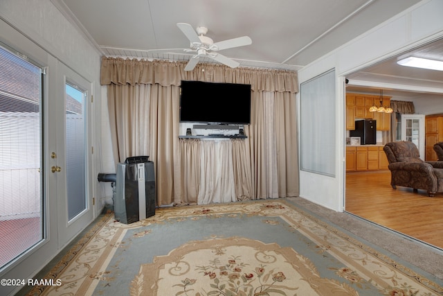 unfurnished living room featuring crown molding, hardwood / wood-style flooring, and ceiling fan with notable chandelier