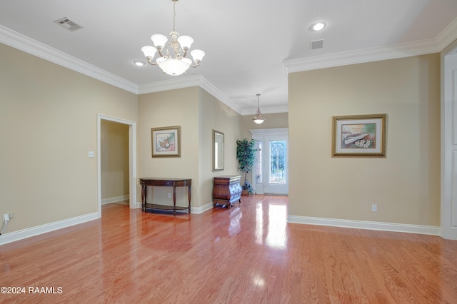 interior space featuring light hardwood / wood-style floors, crown molding, and an inviting chandelier