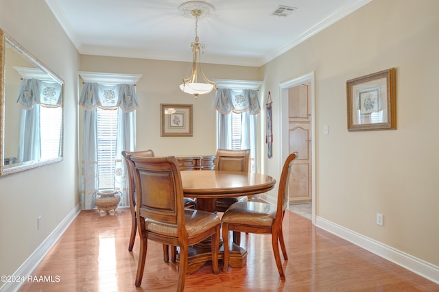 dining area with crown molding and light wood-type flooring