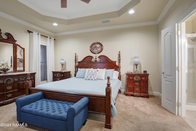 carpeted bedroom featuring connected bathroom, crown molding, a tray ceiling, and ceiling fan