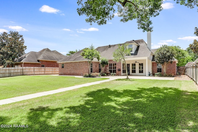 rear view of house featuring french doors and a yard