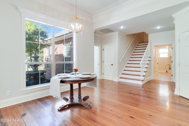 dining space featuring an inviting chandelier, ornamental molding, and wood-type flooring