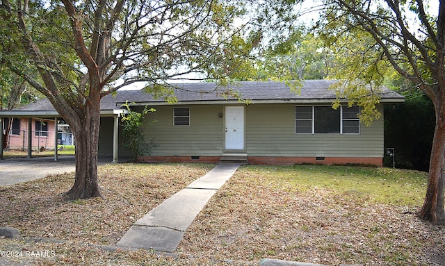 ranch-style home featuring a front lawn and a carport