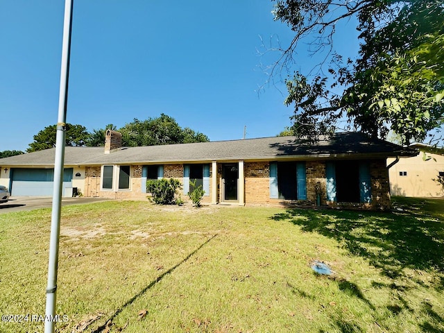 single story home with a garage and a front lawn