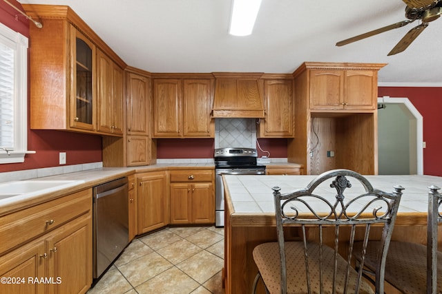 kitchen featuring custom range hood, stainless steel appliances, crown molding, light tile patterned floors, and ceiling fan