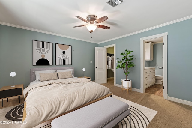 bedroom featuring crown molding, ceiling fan, ensuite bathroom, and light colored carpet