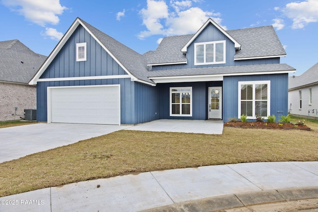 view of front of property featuring roof with shingles, driveway, central AC, board and batten siding, and a front yard